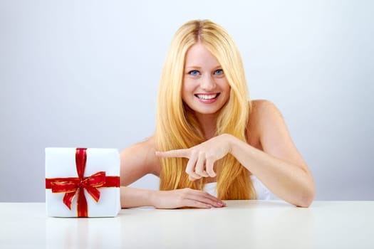 beautiful blonde woman holding a christmas gift is smiling