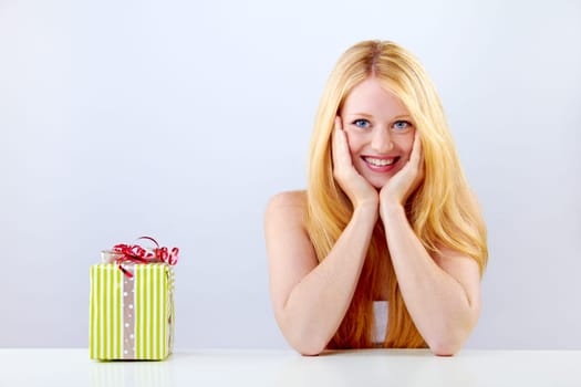 pretty blonde woman with christmas gift is smiling