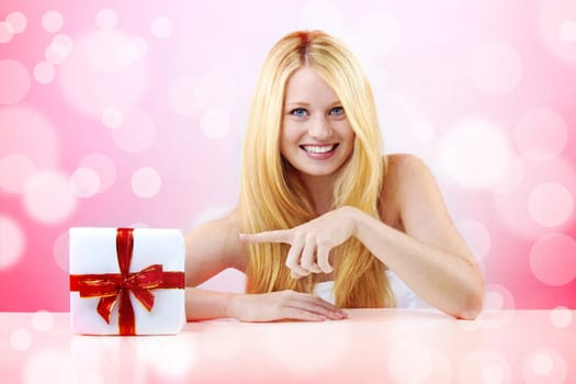 beautiful blonde woman holding a christmas gift is smiling