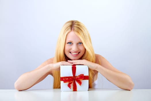 beautiful blonde woman holding a christmas gift is smiling