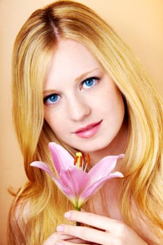 portrait of a young beautiful blonde girl with white flower