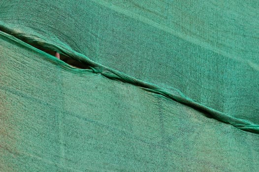 Building under construction green debris netting background.