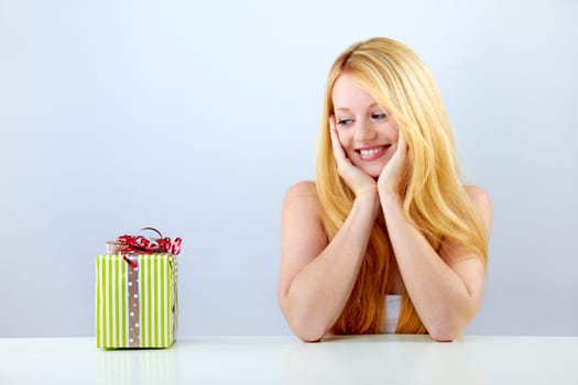 pretty blonde woman with christmas gift is smiling