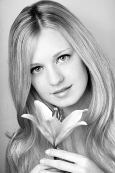 portrait of a young beautiful blonde girl with white flower