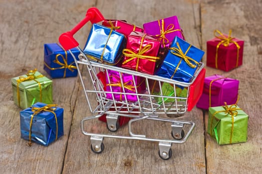 Holiday sale and shopping concept. Cart with colorful gift boxes.
