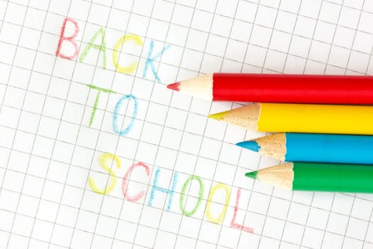 "Back to school"" text and pencils on squared paper"
