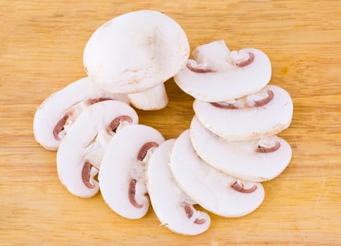 Sliced mushrooms on the wooden cutting board background