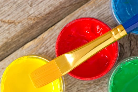 color paints with paintbrush on the wooden plank