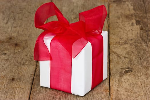 White gift box with red ribbon on the floor