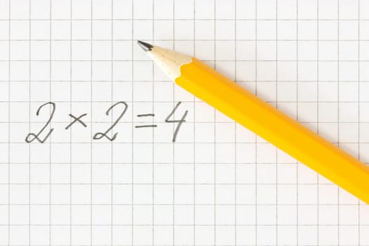 Simple math formula and pencil on squared paper