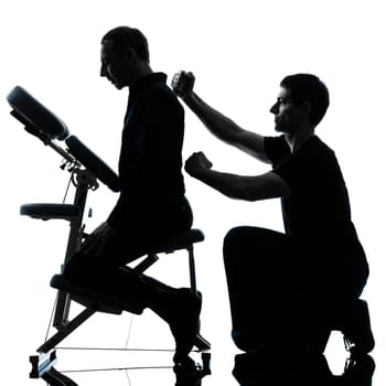 two men performing chair back massage in silhouette studio on white background