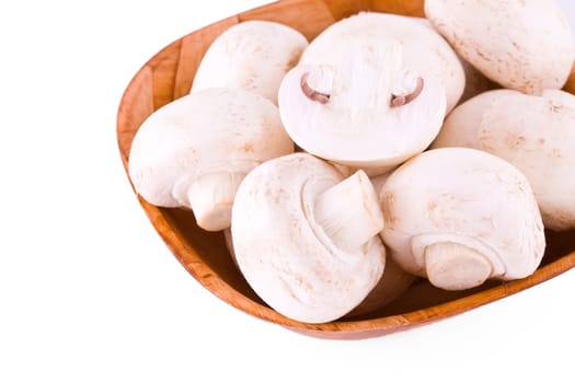 Fresh mushrooms in a wooden bowl isolated on white