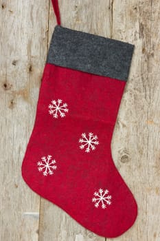 Red christmas sock hung on the old wooden wall