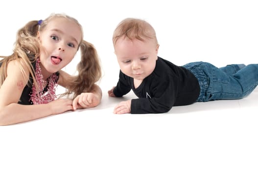 Newborn baby boy with sister showing tongue