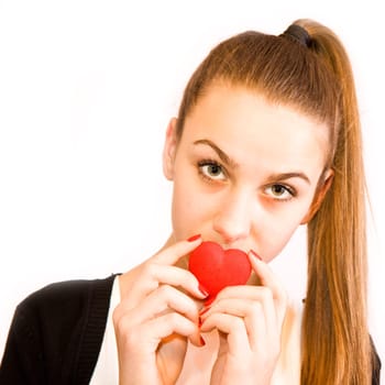 Young girl kisses red valentine's toy heart