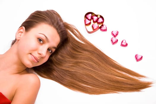 Pretty young girl and chocolate hearts isolated on white