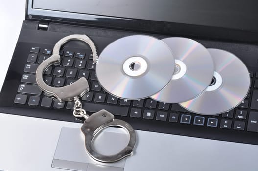 Handcuffs and CD - ROM on laptop