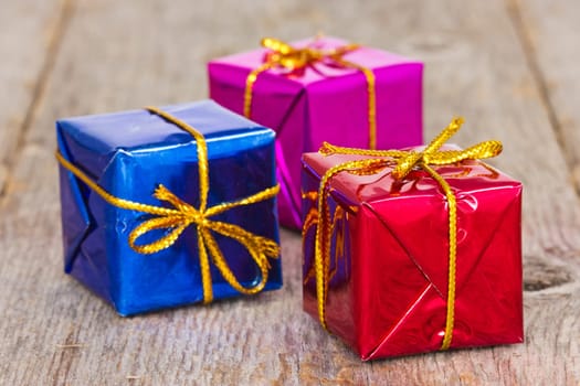 three color gift boxes on the wooden floor