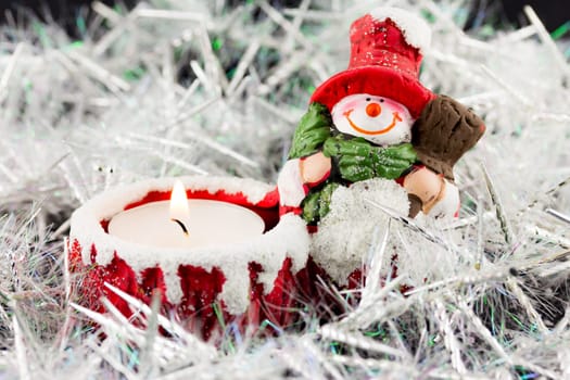 A Christmas snowman candle with fire