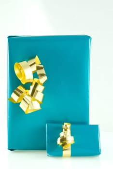 two blue gifts with gold ornamentation, on white