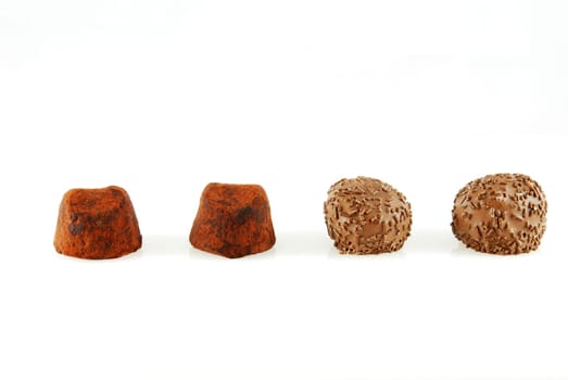 four chocolate candies in a row, two different kinds, on white