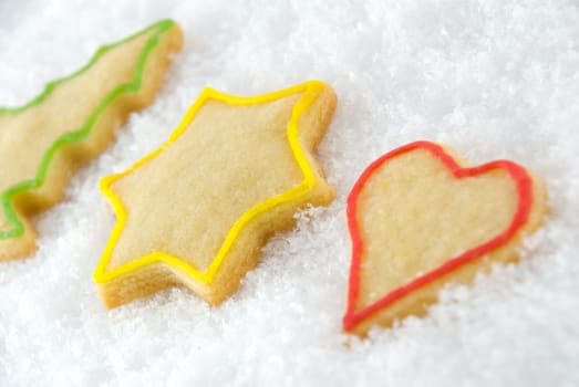 three christmas cookies lying in the snow