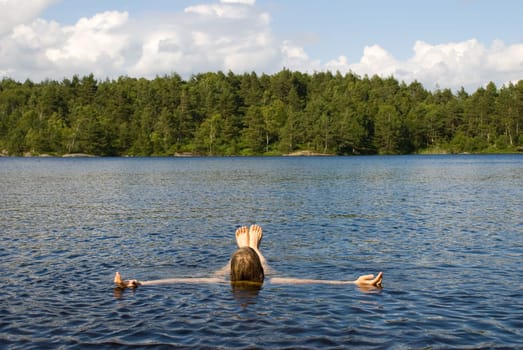 a person lying in the water for recreation i a natural environment