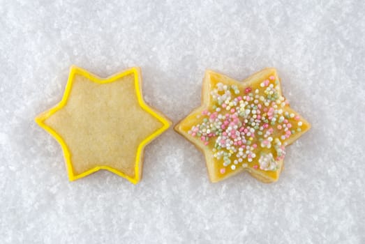 two christmas cookies in star-figure lying in the snow