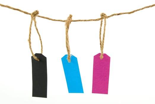 three tags in different colours hanging next to each other, isolated