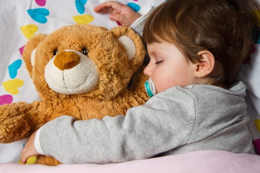 Sweet child sleeping with teddy bear