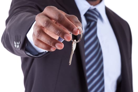 Young African American businessman holding a house key, isolated on white background