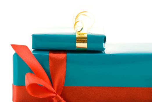 a cutout of two blue gifts with red and gold decorations, isolated