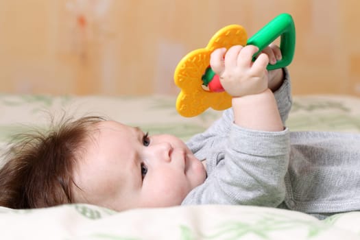Portrait of a playing baby lying down on back