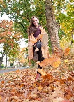 Young woman running in autumn leaves
