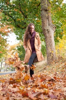 Young woman running in autumn leaves