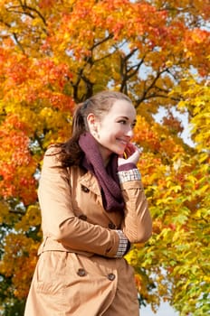 Cheerful young woman in autumnal park