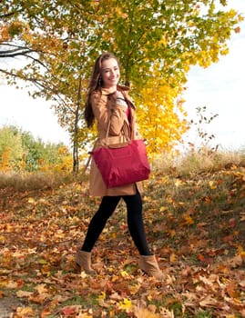 Happy young woman in autumnal park