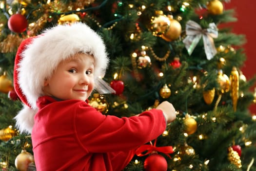 happy boy decorating Christmas tree