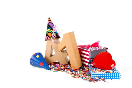 Number of age in a colorful studio setting with paper party hats, a red heart and gifts on a bottom of confettie
