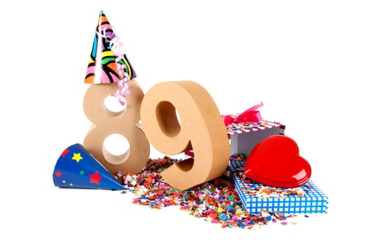 Number of age in a colorful studio setting with paper party hats, a red heart and gifts on a bottom of confettie