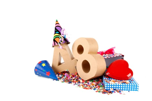Number of age in a colorful studio setting with paper party hats, a red heart and gifts on a bottom of confettie
