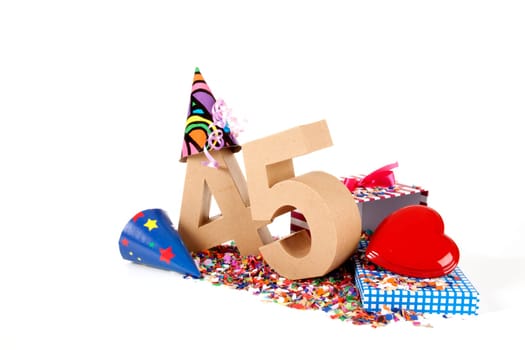 Number of age in a colorful studio setting with paper party hats, a red heart and gifts on a bottom of confettie