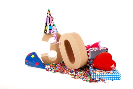 Number of age in a colorful studio setting with paper party hats, a red heart and gifts on a bottom of confettie