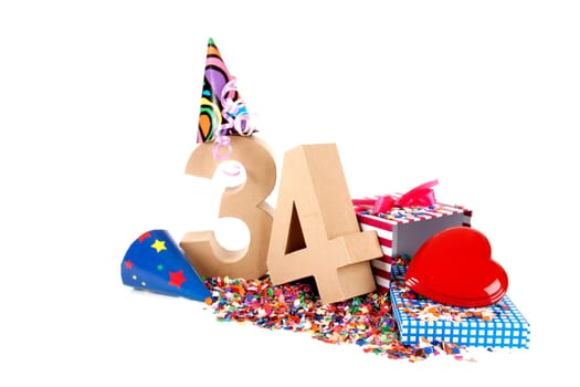 Number of age in a colorful studio setting with paper party hats, a red heart and gifts on a bottom of confettie