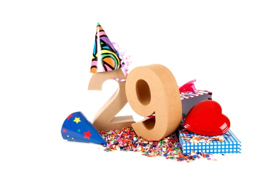 Number of age in a colorful studio setting with paper party hats, a red heart and gifts on a bottom of confettie