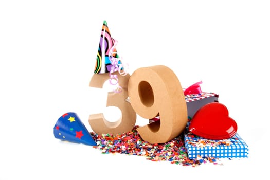 Number of age in a colorful studio setting with paper party hats, a red heart and gifts on a bottom of confettie