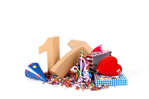 Number of age in a colorful studio setting with paper party hats, a red heart and gifts on a bottom of confettie