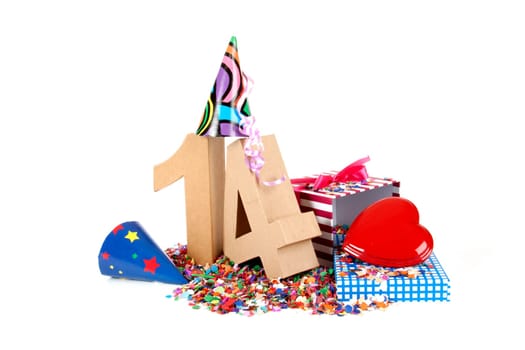 Number of age in a colorful studio setting with paper party hats, a red heart and gifts on a bottom of confettie