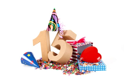 Number of age in a colorful studio setting with paper party hats, a red heart and gifts on a bottom of confettie