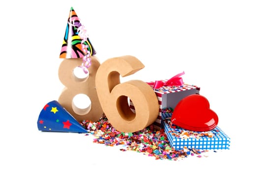 Number of age in a colorful studio setting with paper party hats, a red heart and gifts on a bottom of confettie